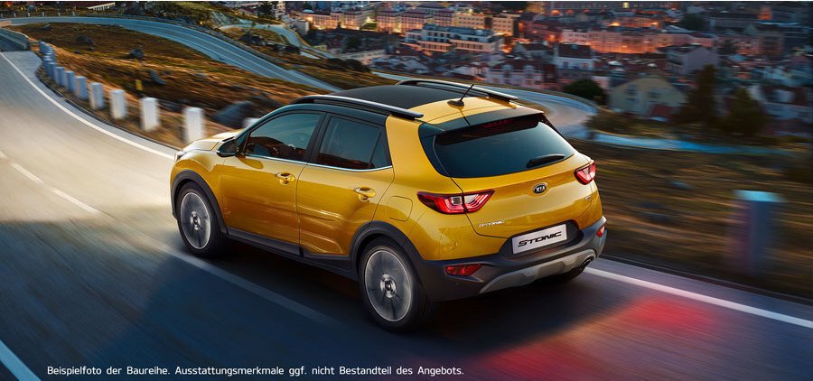 Ein gelber SUV fährt eine kurvige Straße entlang, mit einer Stadtlandschaft im Hintergrund bei Dämmerung.